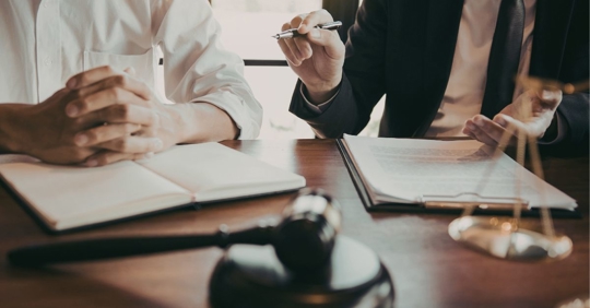 couple signing documents in lawyer's office